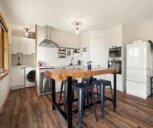 a kitchen with a wooden table and black stools at 1860 Lawrence Cottage in Lawrence