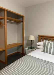 a bedroom with a large bed and a lamp at 1860 Lawrence Cottage in Lawrence