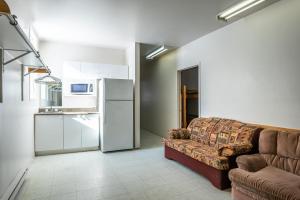 a living room with a couch and a refrigerator at Camp Val Notre-Dame in Herouxville