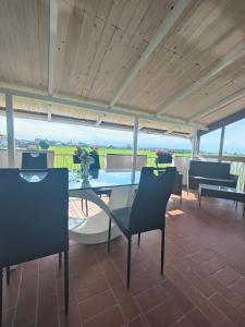 a dining room with a glass table and chairs at Mini Loft con terrazza vista Alpi in Vinovo