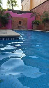 a swimming pool with blue water in front of a building at Casa Sorpresa in Sayulita +2 photos