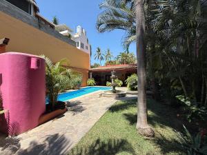 a house with a swimming pool and a palm tree at Casa Sorpresa in Sayulita