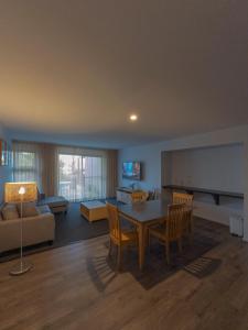 a living room with a table and chairs and a couch at Corrigans Cove Resort Batemans Bay in Batemans Bay