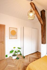 a bedroom with a white cabinet and a potted plant at Podkrovní Apartmán in Třebíč
