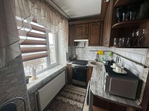 a small kitchen with a sink and a stove at Apartment in Zolotonosha