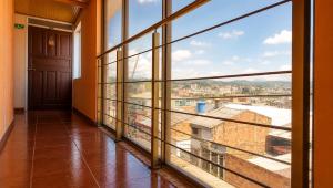 a room with large windows with a view of a city at Apartamentos CasaMJ Tunja Confort y Parqueadero in Tunja