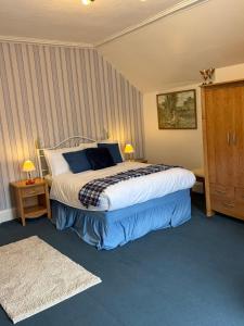 a bedroom with a bed and two night stands and a bed sidx sidx at Kinkell House in Inverness