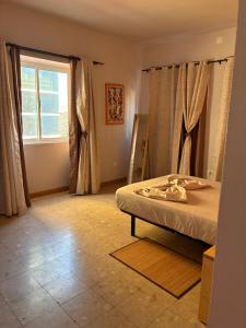 a bedroom with a bed and a window at Sol, Terra e Mar- No coração do Plateau in Praia
