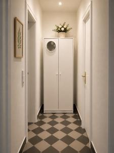 a hallway with a white cabinet and a checkered floor at Peaceful & Cozy Apartment in Dresden