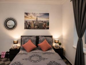 a bedroom with a bed with two orange pillows at Peaceful & Cozy Apartment in Dresden