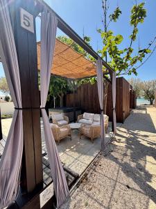 acovered patio with a couch and chairs under a canopy at Stylish beach house in Privlaka in Privlaka