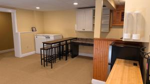 a kitchen with white cabinets and black stools at Private Two Queen Beds Room Near UPEI & Downtown Cozy Retreat Near Everything in Charlottetown