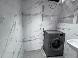 a white bathroom with a washing machine and a sink at Appartement No 2 à Tamraght in Tamraght Ouzdar