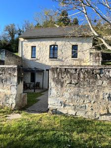 an old stone house with a stone wall at Studio La Parenthèse in Chinon