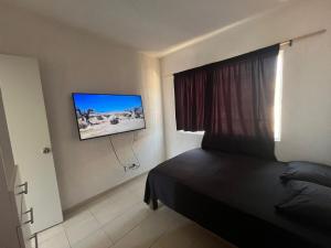 a bedroom with a bed and a tv on the wall at Casa Claliz in Los Algodones