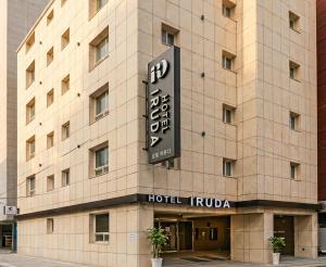 a building with a sign on the side of it at Busan Station Iruda Hotel in Busan