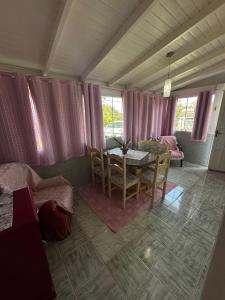 a living room with a table and a dining room at casarosaencantada -villaencantorosa in Gramado +25 photos