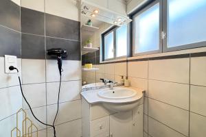 a bathroom with a sink and a phone on the wall at Le Cherpin I Duplex charmant in Roanne +12 photos