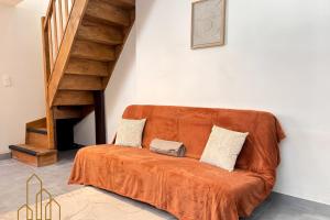 an orange couch in a room with a staircase at Le Cherpin I Duplex charmant in Roanne