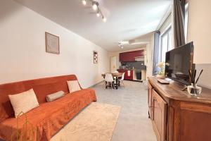 a living room with a couch and a flat screen tv at Le Cherpin I Duplex charmant in Roanne