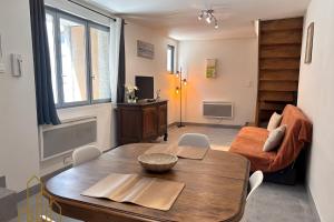 a living room with a table and a couch at Le Cherpin I Duplex charmant in Roanne