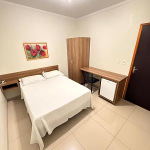 a bedroom with a bed and a desk at Hotel Rio Grande in Dourados
