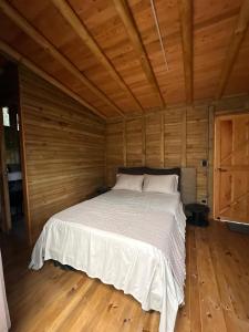 a bedroom with a bed in a wooden room at Casa dharma in Medellín