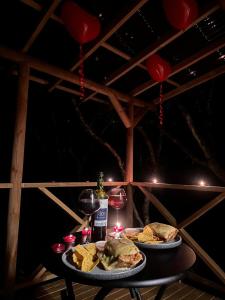 a table with two plates of food and a bottle of wine at Casa dharma in Medellín