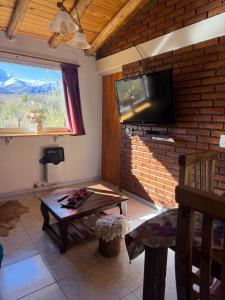 a living room with a table and a tv on a brick wall at Gr Turismo in Los Molles