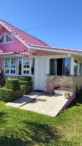 a pink house with a walkway in front of it at casarosaencantada -villaencantorosa in Gramado