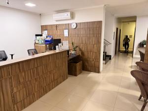 a lobby of a pharmacy with a counter and chairs at Hotel Rio Grande in Dourados