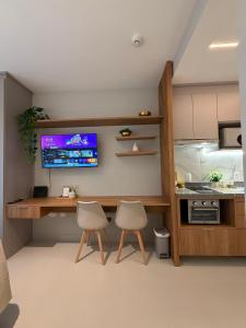 a kitchen with two chairs and a desk with a tv at 07 La Limeña Estúdio completo perto do consulado in São Paulo