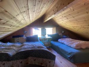 a room with two beds in a attic at Hannebu, hytte med 3 soverom, 2 bad og sovehems in Kyrkjebygdi