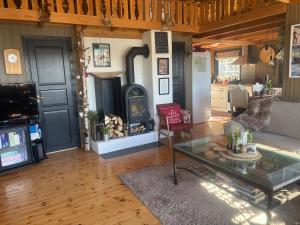 a living room with a couch and a fireplace at Hannebu, hytte med 3 soverom, 2 bad og sovehems in Kyrkjebygdi