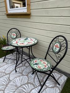 two tables and two chairs sitting on a patio at Leilighet midt i Sokndal sentrum in Sokndal