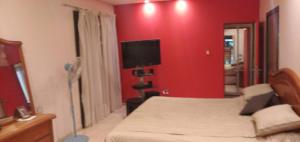 a hotel room with a bed and a flat screen tv at Posada Alto Verde in Belén