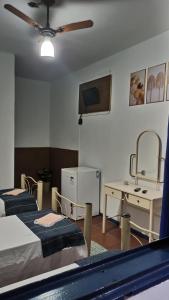 a room with two beds and a tv and a table at Pousada Regis Bocaina SJB in São José do Barreiro