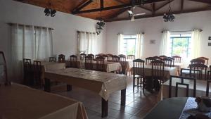 a dining room with tables and chairs and windows at Pousada Regis Bocaina SJB in São José do Barreiro