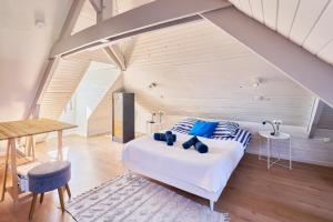 a bedroom with a bed with blue pillows and a table at Ker Berthe - Maison spacieuse - lumineuse - 4 chambres in Cesson-Sévigné