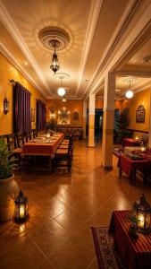a large room with tables and chairs in a building at Riad Mifis in Rissani