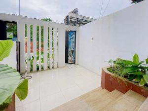 a balcony with plants and a white wall at Arista - Thanh My Loi in Ho Chi Minh City