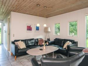 a living room with a couch and a table at 8 person holiday home in Ørsted in Kare