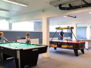 two children playing pool in a room with a pool table at Apartment with loft in Ringkøbing in Ringkøbing