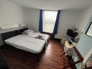 a small bedroom with a bed and a window at Breeze Guest House in Bootle