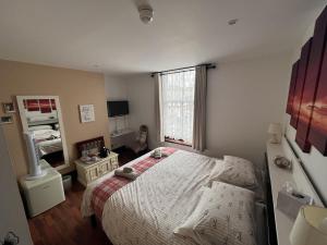 a small bedroom with a bed and a window at Breeze Guest House in Bootle