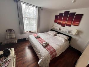 a bedroom with a bed with two teddy bears on it at Breeze Guest House in Bootle