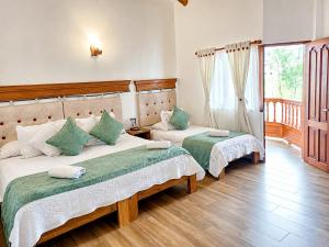 a bedroom with two beds and a balcony at Hotel las Palmas in Villa de Leyva