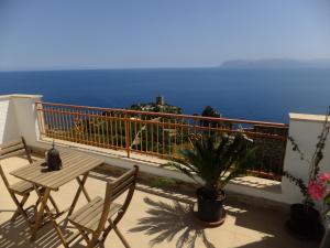balcone con tavolo, sedie e vista sull'oceano di B&B Talìa a Scopello