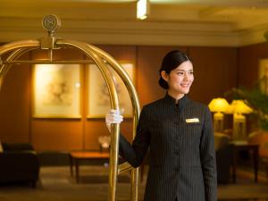 神戸市にある神戸ベイシェラトン ホテル&タワーズの柱を持ったホテルロビーに立つ女性