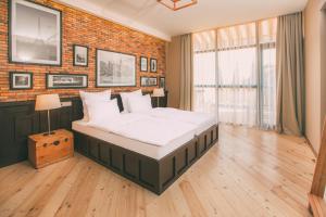 a bedroom with a large bed and a brick wall at Kisi Boutique Hotel in Tbilisi City